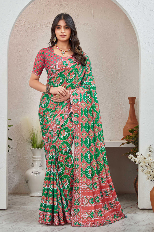 Woman wearing a red and green patterned saree in a decorated room Glanzavi