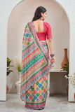 Woman wearing a colorful saree with a pink blouse in an indoor setting Glanzavi
