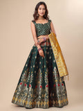 Woman wearing a dark green embroidered lehenga with a gold dupatta on a beige background Glanzavi