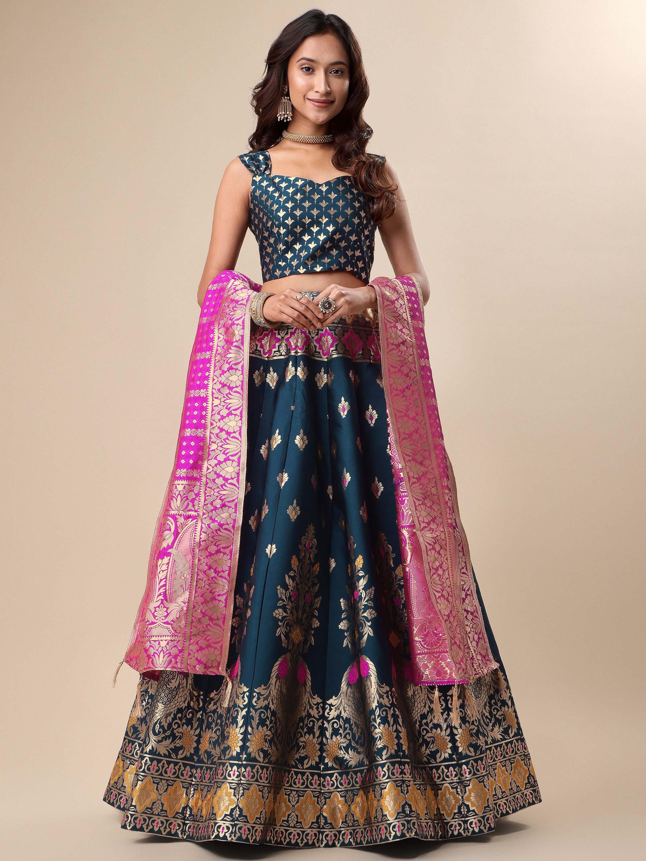 Woman wearing a traditional blue and pink lehenga with a beige background Glanzavi