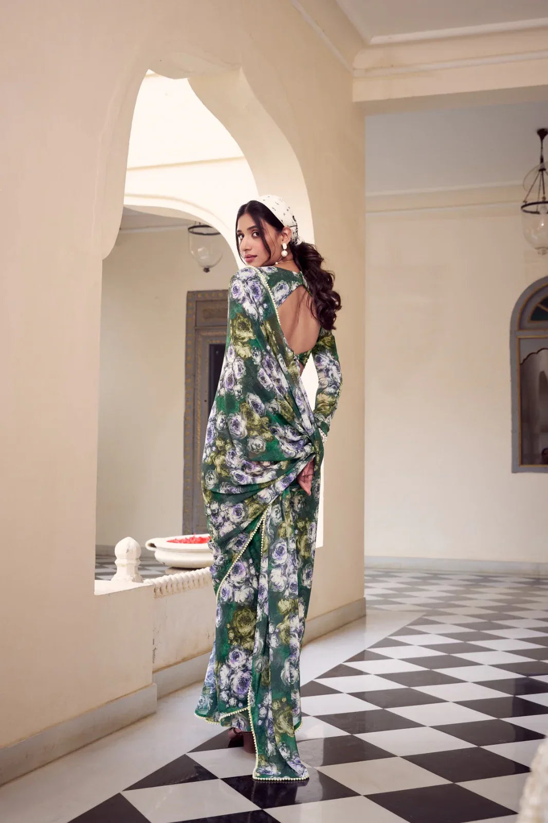 Woman in a floral saree standing in an elegant interior setting with checkered floor Glanzavi.