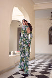 Woman in a floral saree standing in an elegant interior setting with checkered floor Glanzavi.