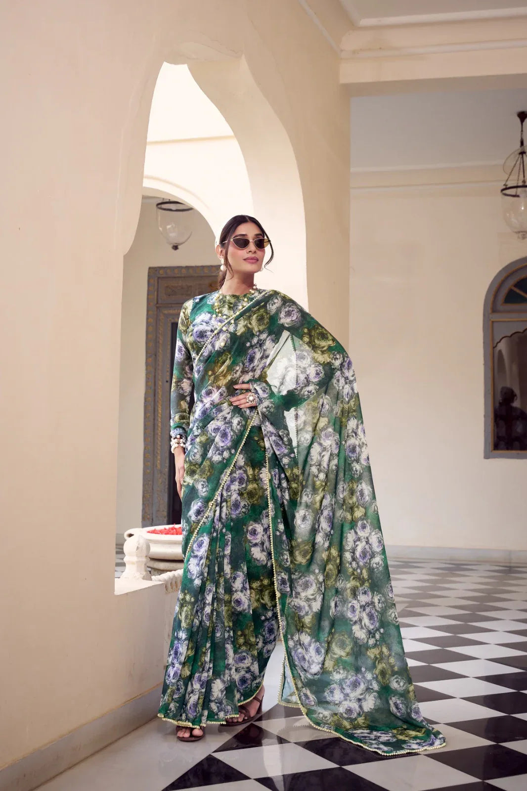 Woman in a floral saree standing in an elegant interior setting Glanzavi