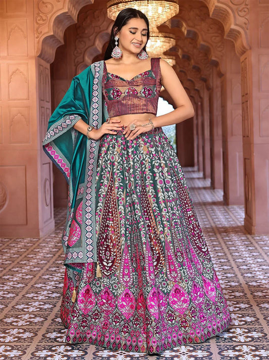 Woman in a traditional outfit with a colorful patterned dress and green dupatta standing in an ornate architectural setting Glanzavi.