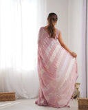 Woman wearing a pink saree with gold patterns in a minimalistic room Glanzavi
