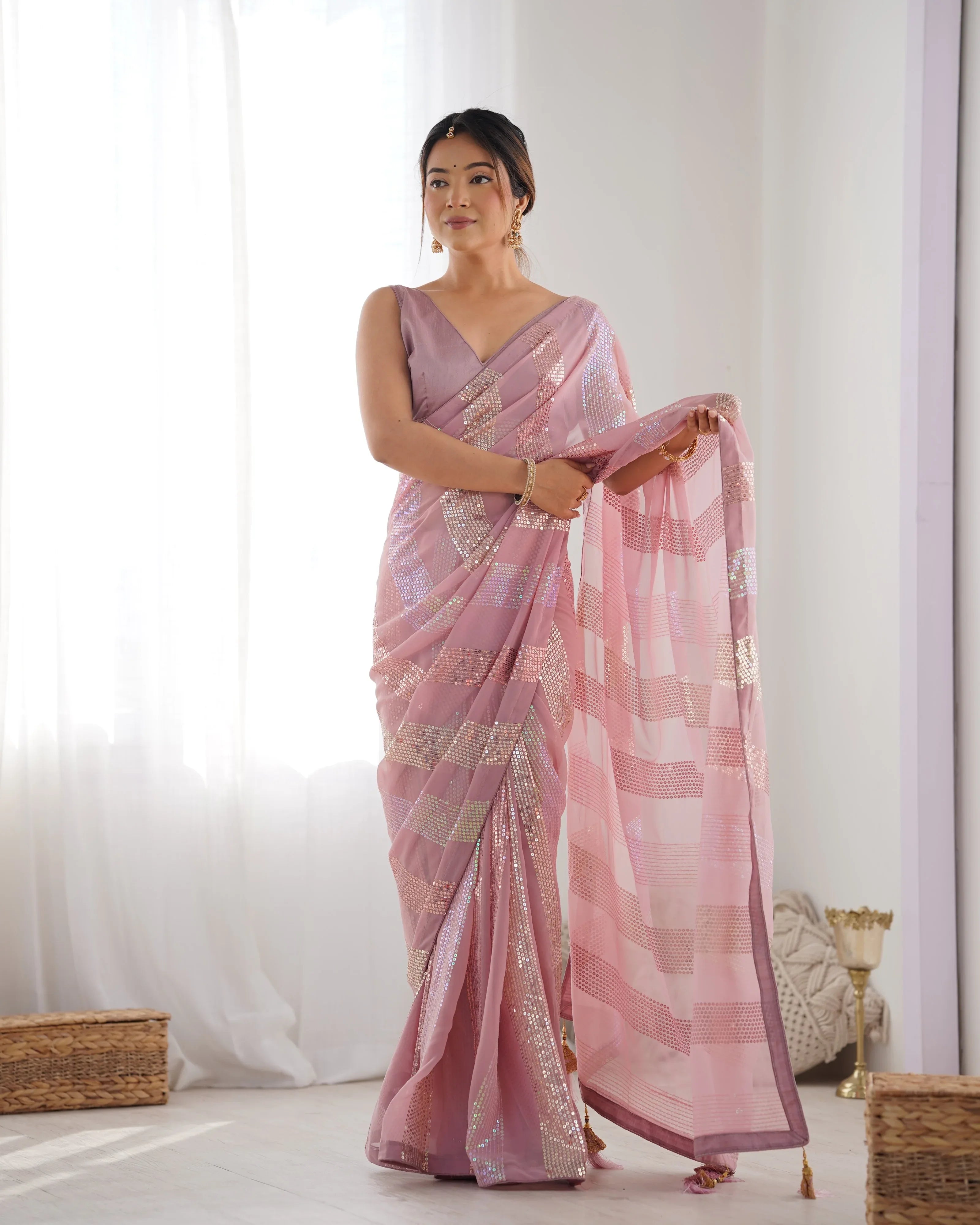 Woman wearing a pink saree with a white background Glanzavi