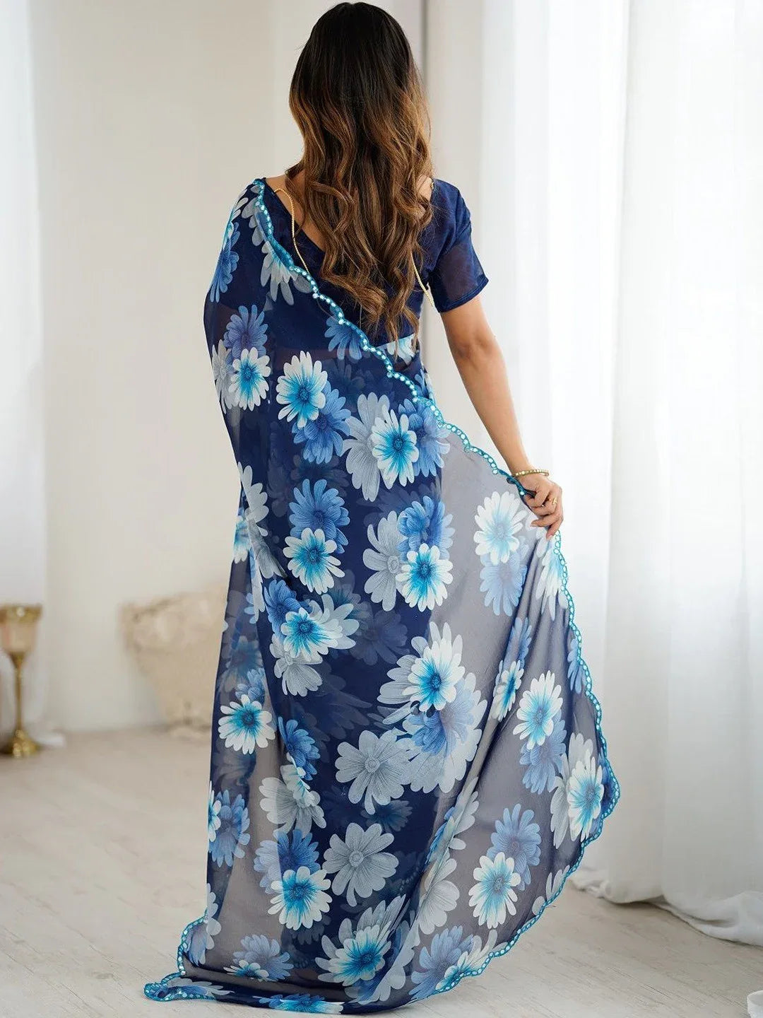 Woman wearing a blue floral dress in a bright room Glanzavi