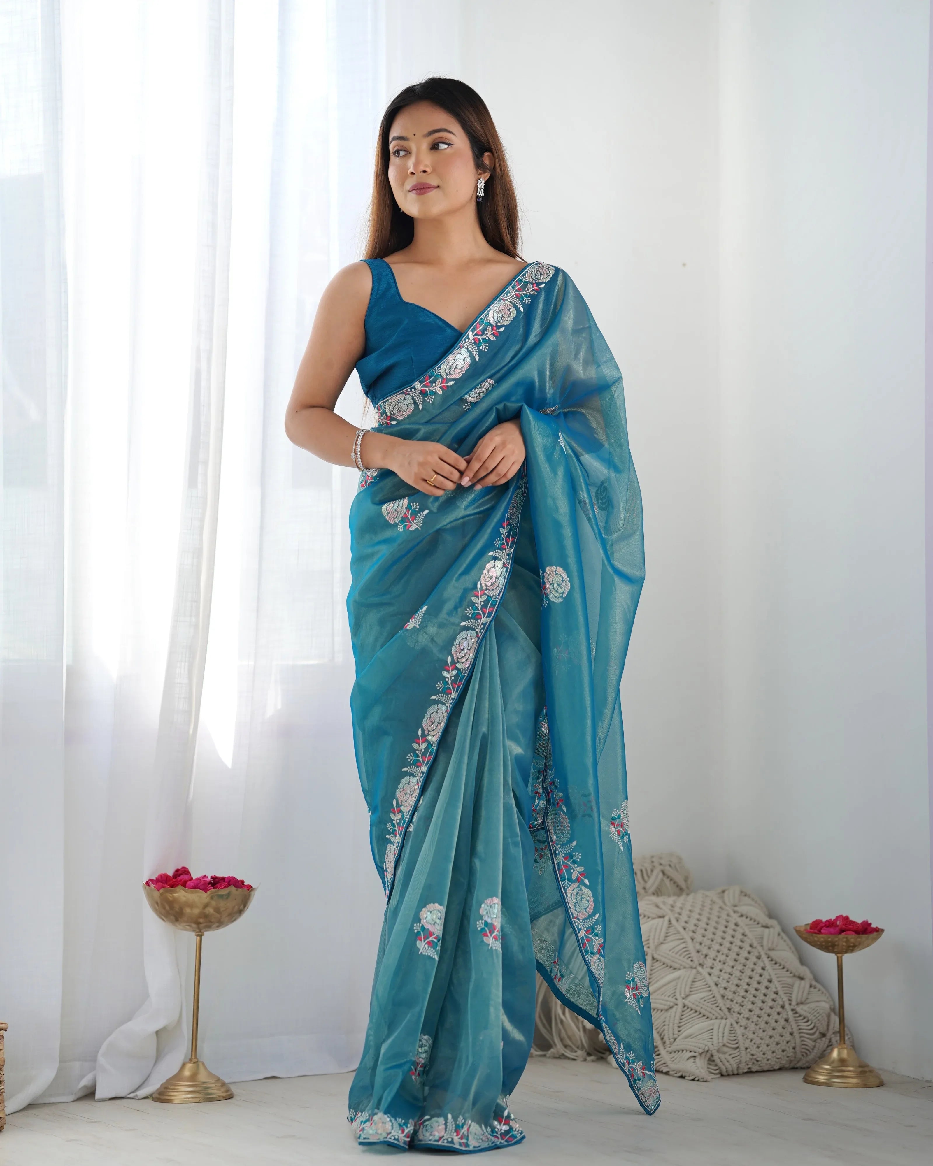 Woman wearing a blue saree with a white background Glanzavi