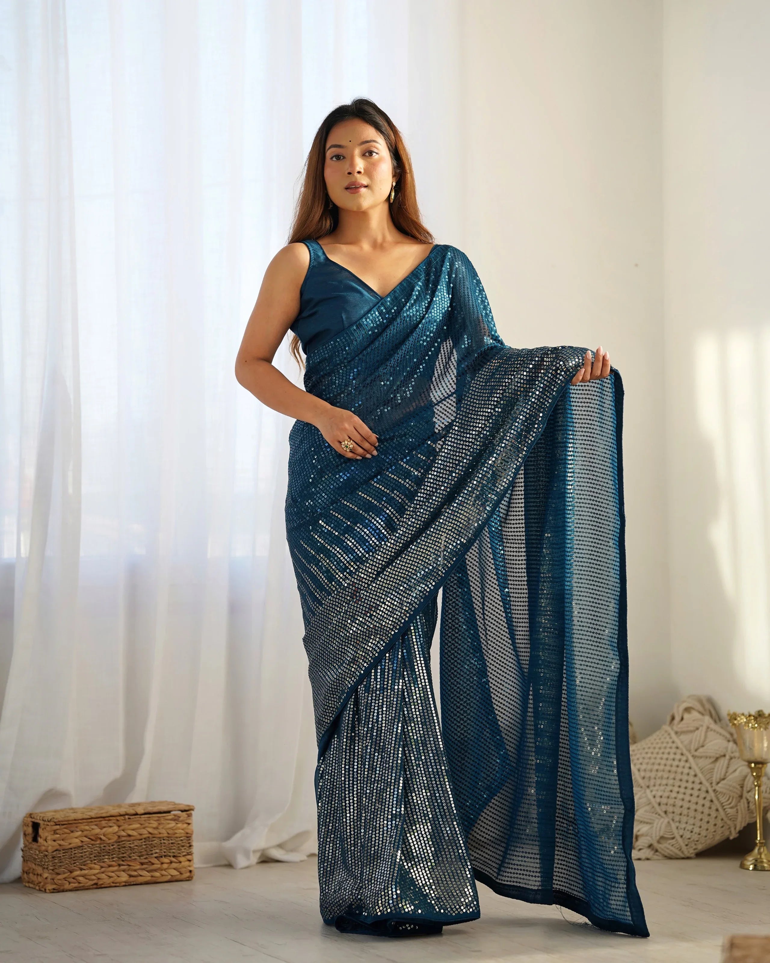 Woman wearing a blue saree with a white background Glanzavi