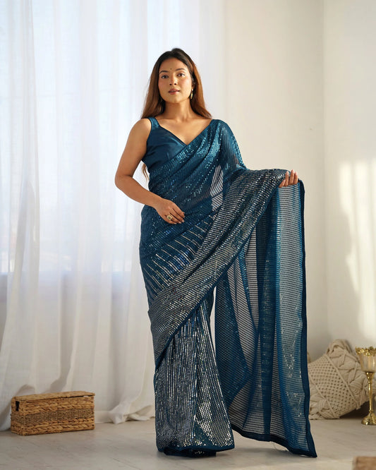 Woman wearing a blue saree with a white background Glanzavi