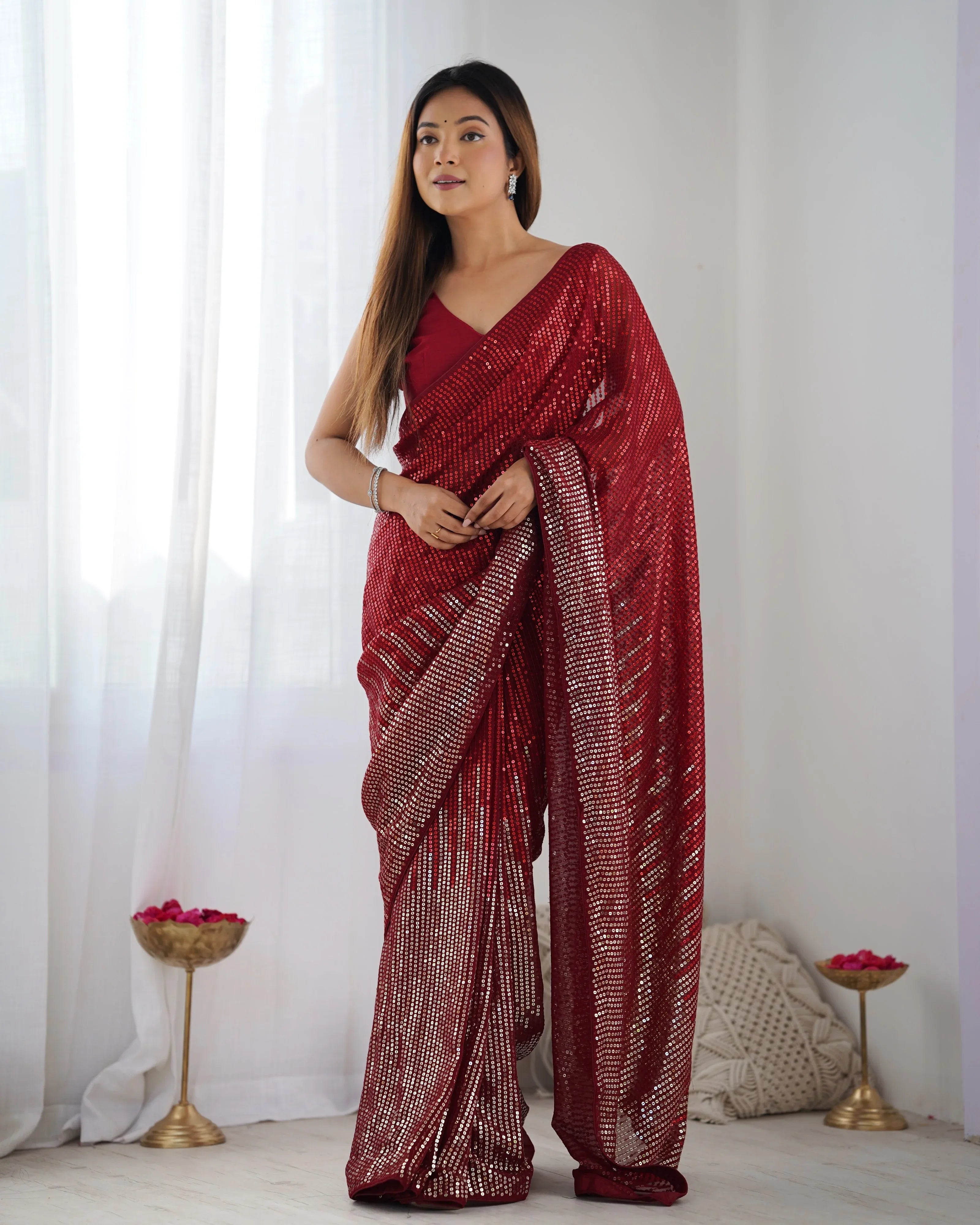 Woman wearing a red saree with a white background Glanzavi