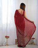 Woman wearing a red saree with a white curtain background Glanzavi