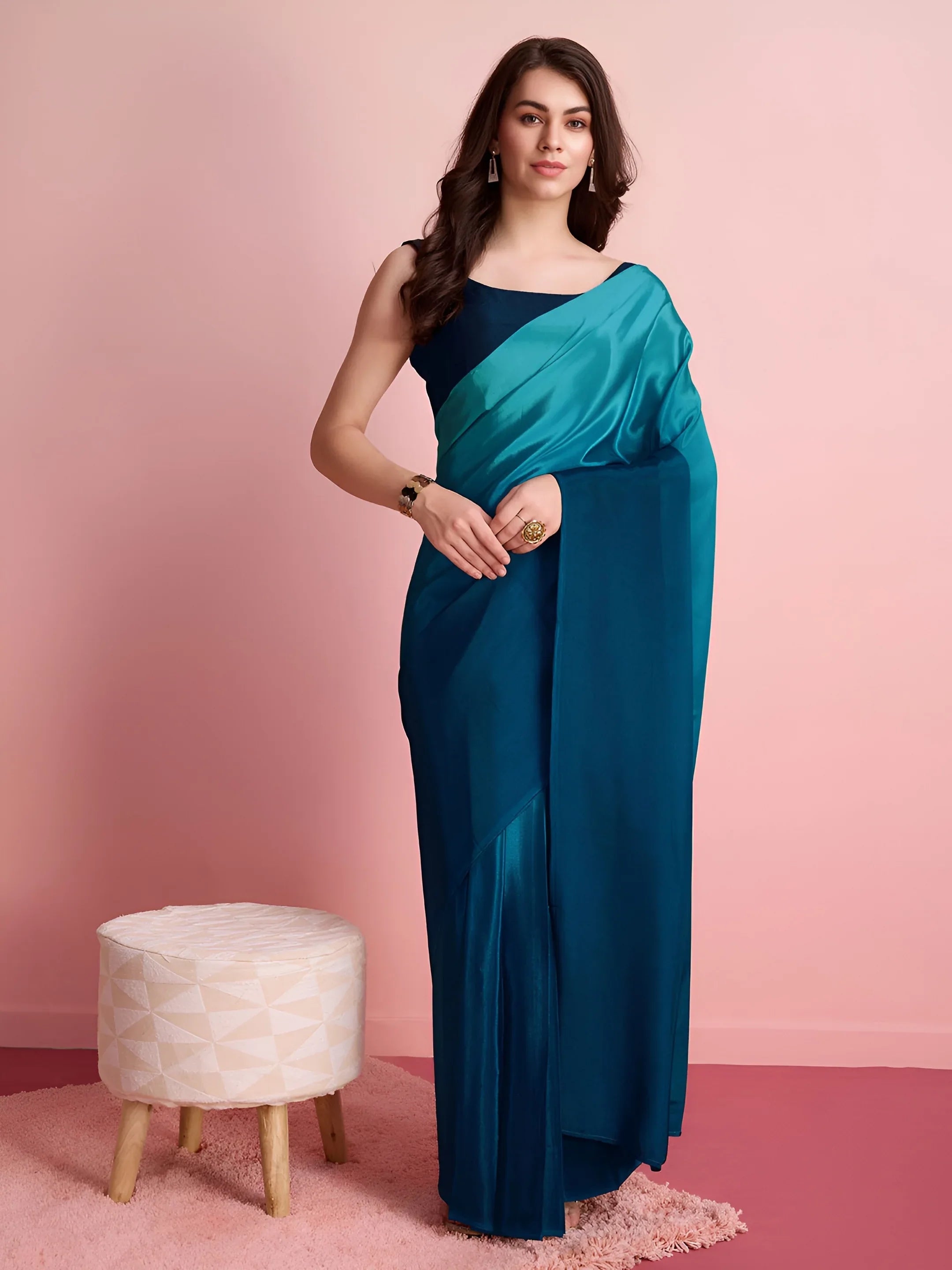 Woman wearing a blue one-shoulder dress against a pink background Glanzavi