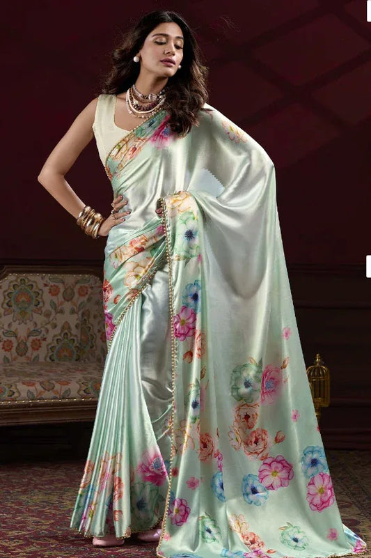 Woman wearing a light blue saree with floral patterns in a room setting Glanzavi.