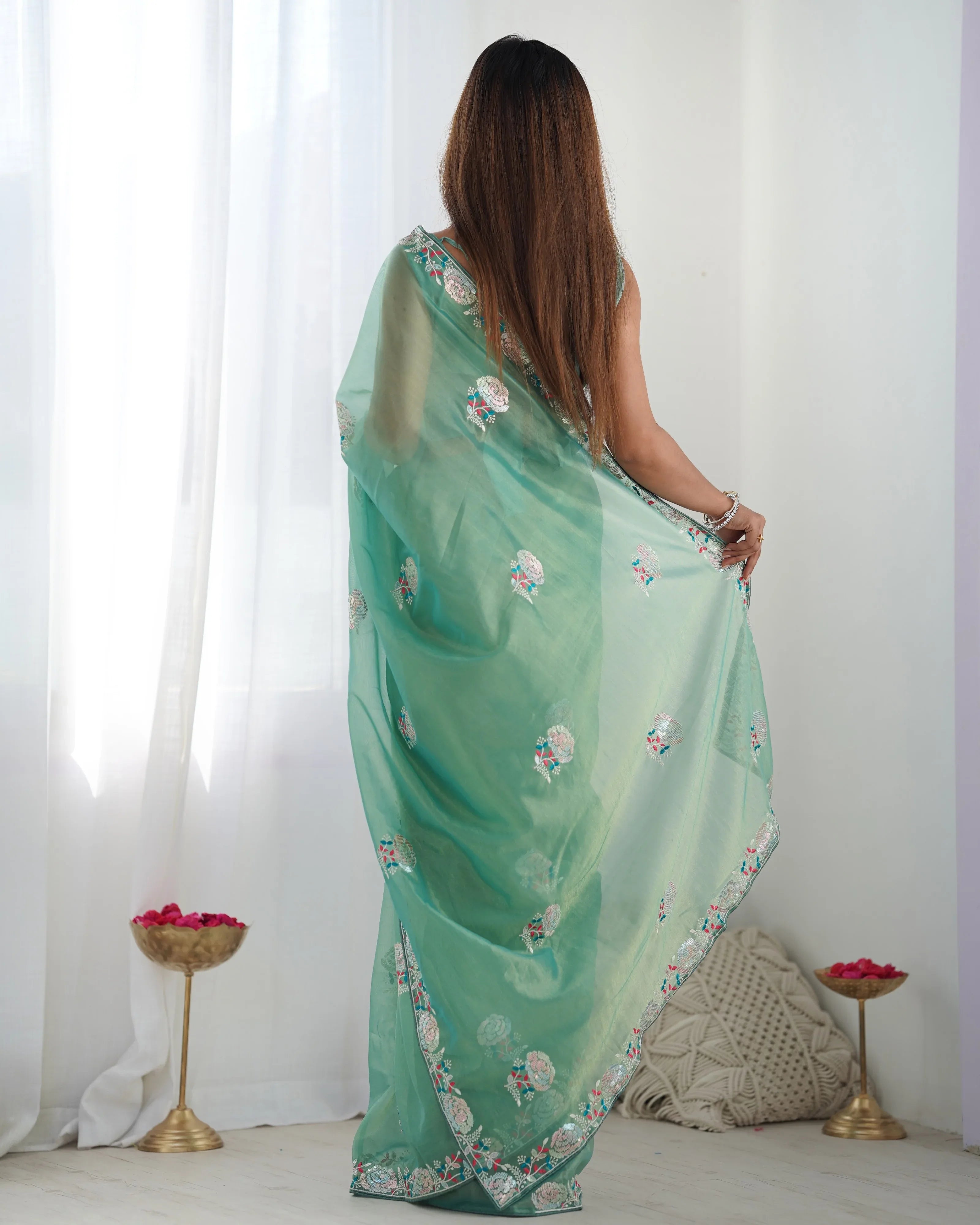 Woman wearing a green floral saree in a minimalistic setting Glanzavi