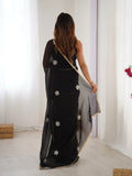 Woman wearing a black saree with silver floral patterns in a minimal indoor setting Glanzavi.