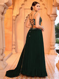 Woman in a dark green evening gown with intricate detailing in an ornate setting Glanzavi