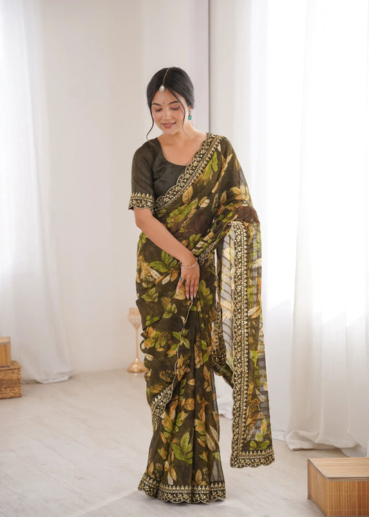 Woman wearing a green and black patterned saree in a minimal white room Glanzavi.