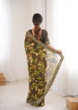 Woman wearing a green floral saree with a white background Glanzavi