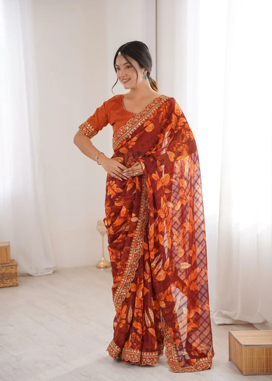 Woman wearing a traditional orange and brown saree with a white curtain background Glanzavi