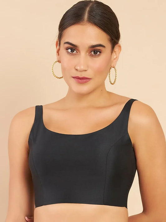 Woman wearing a black sports bra against a beige background Glanzavi