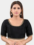 Woman wearing a black blouse with gold trim on a white background Glanzavi