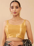 Woman wearing a yellow satin top against a beige background Glanzavi