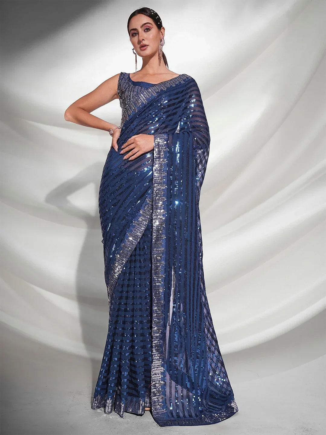 Woman wearing a blue saree with silver sequins on a white background Glanzavi