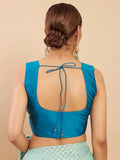 Woman wearing a blue sleeveless top with an open back on a beige background Glanzavi