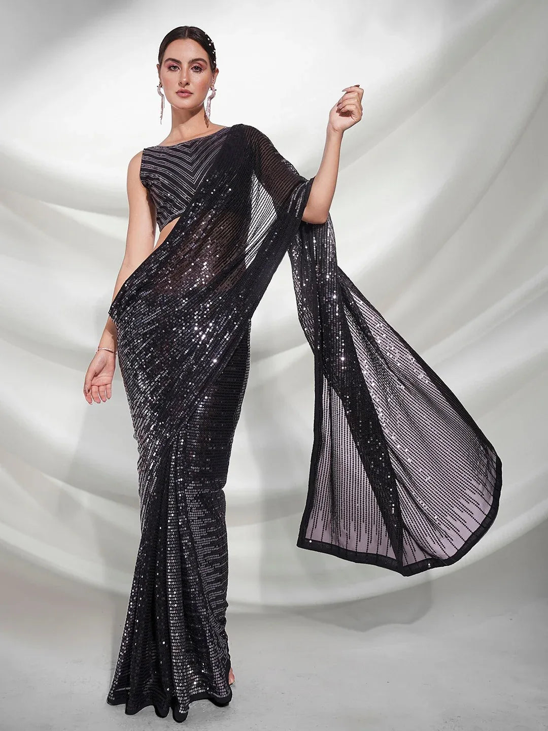 Woman wearing a black saree with a white background Glanzavi