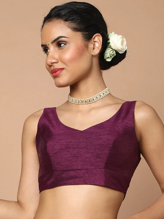 Woman wearing a purple top with a beige background Glanzavi