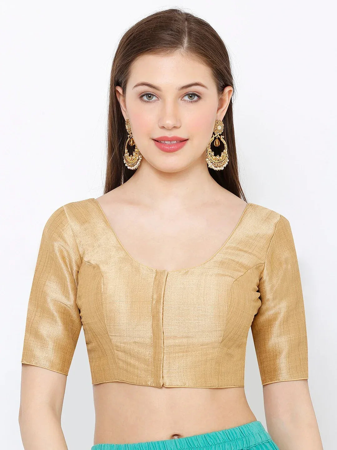 Woman wearing a gold blouse with a plain background Glanzavi