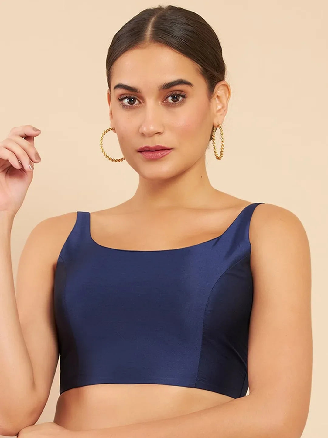 Woman wearing a navy blue top against a beige background Glanzavi