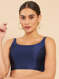Woman wearing a navy blue top against a beige background Glanzavi