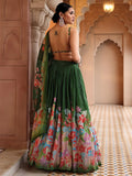Woman in a green floral saree standing in an ornate architectural setting Glanzavi