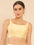 Woman wearing a yellow top against a beige background Glanzavi