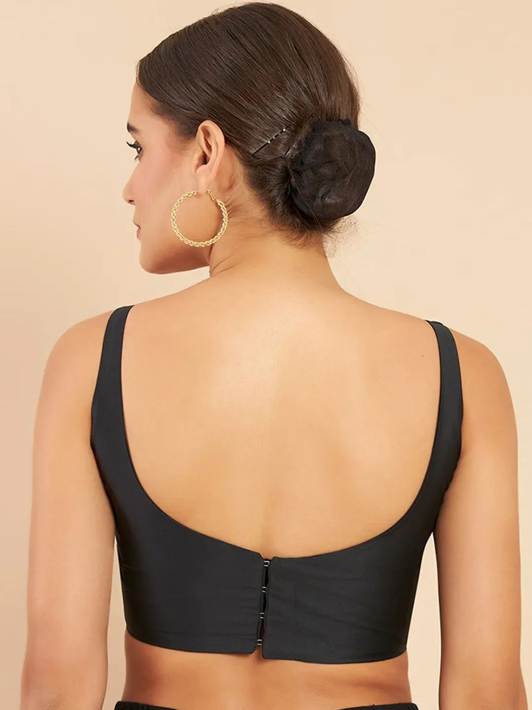 Woman wearing a black bralette on a beige background Glanzavi