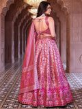 Woman in a pink embroidered traditional outfit standing in an ornate hallway Glanzavi.