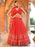 Woman in a red traditional outfit with patterns standing in an ornate architectural setting Glanzavi.