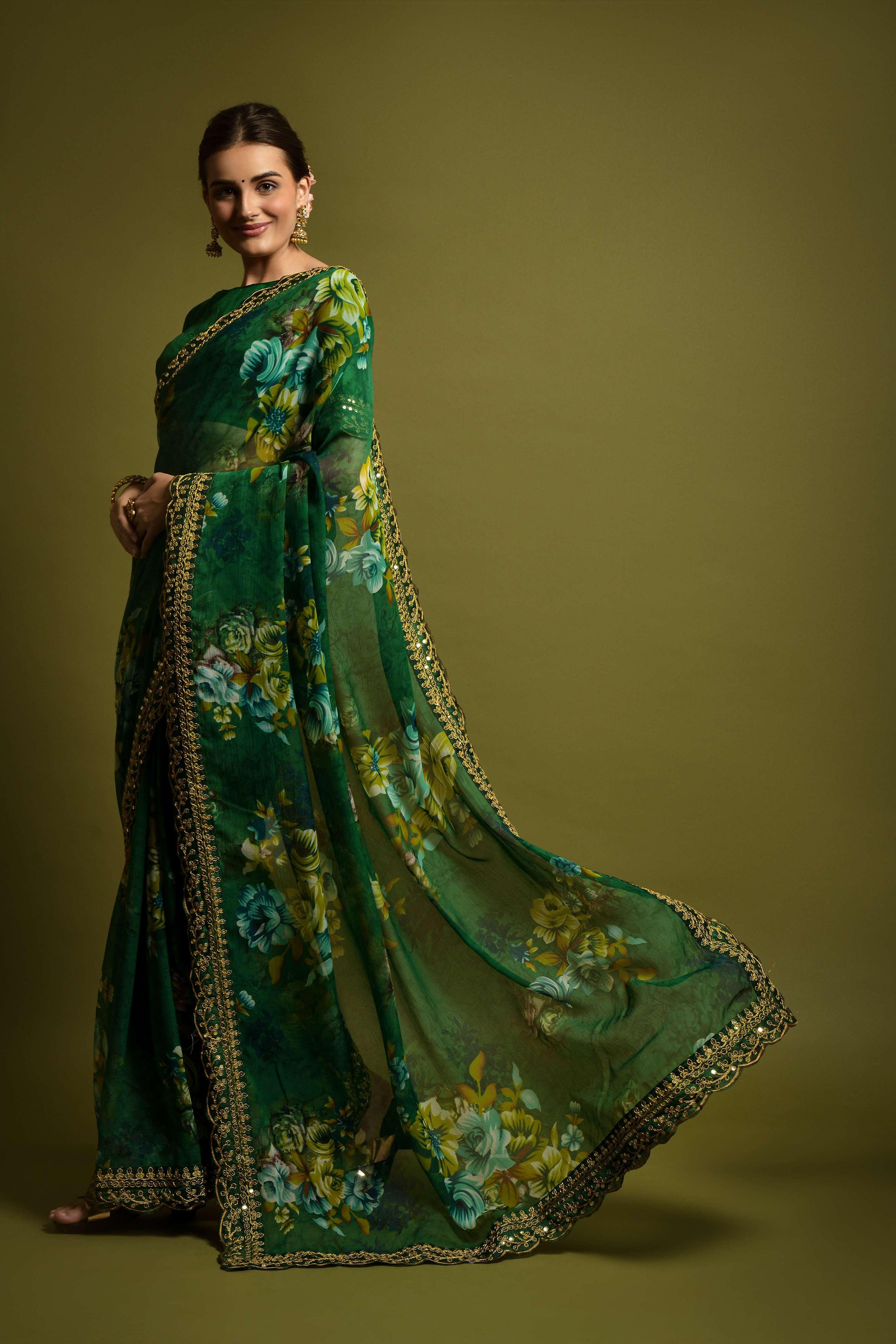 Woman wearing a green floral saree with a plain background Glanzavi