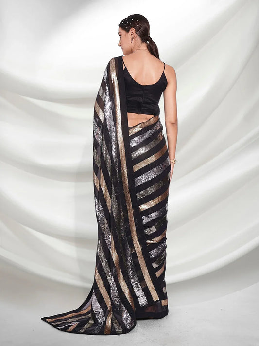 Woman wearing a black and gold saree with a white background Glanzavi