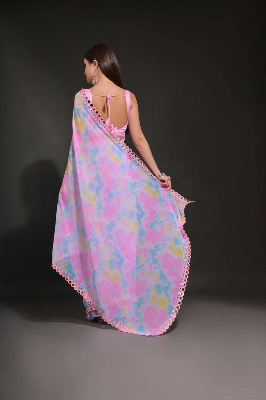 Woman wearing a colorful floral dress with pink trim on a dark background Glanzavi