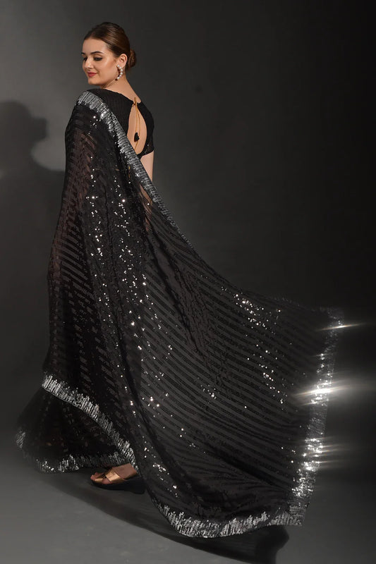 Woman wearing a black sequin gown on a dark background Glanzavi