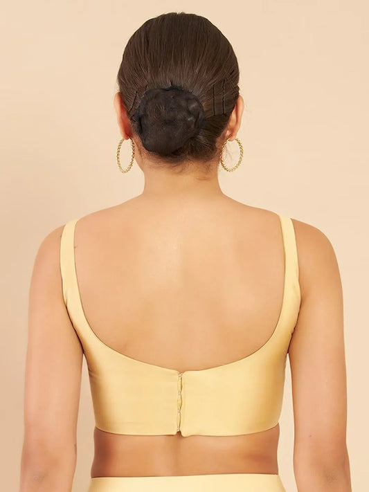 Woman wearing a yellow top with a beige background Glanzavi