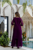 Woman in a purple dress standing by a pool with palm trees in the background Glanzavi