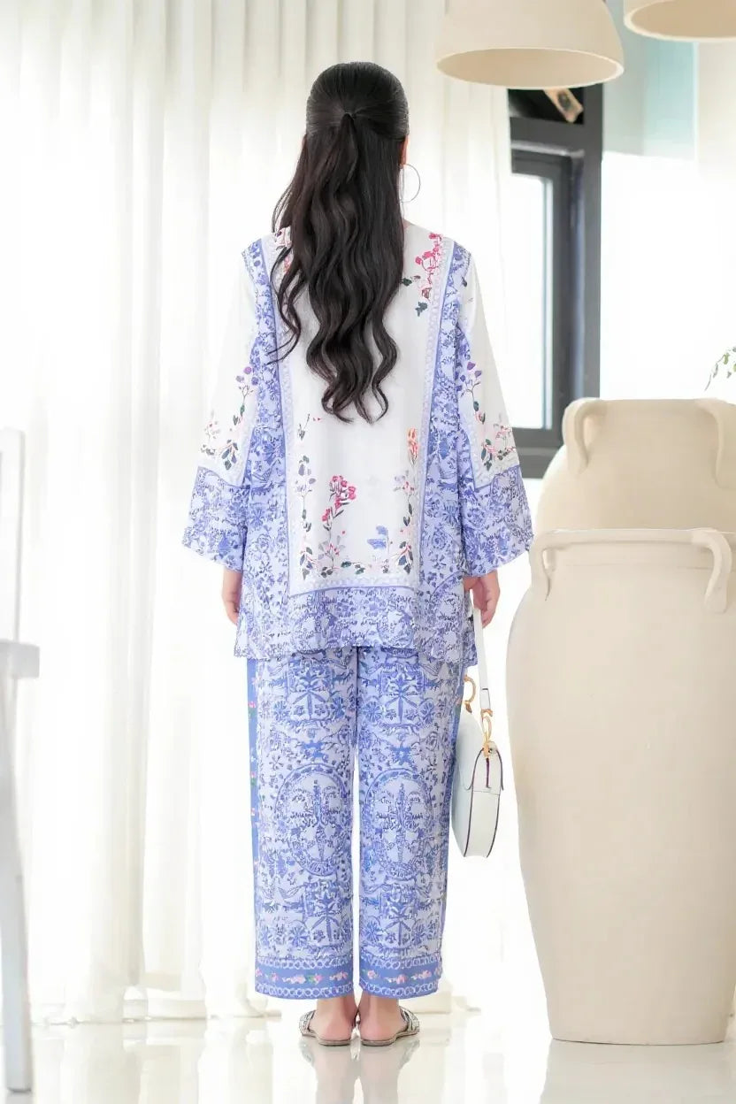 Woman wearing a blue and white floral outfit in a bright room Glanzavi