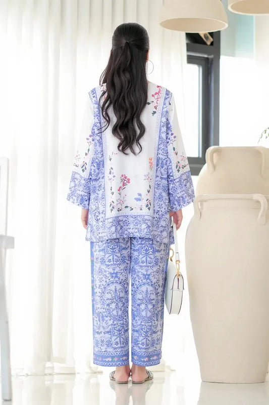 Woman wearing a blue and white floral outfit in a bright room Glanzavi