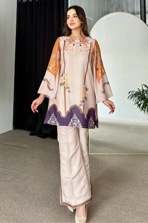 Woman wearing a traditional outfit with floral patterns in a minimal indoor setting Glanzavi