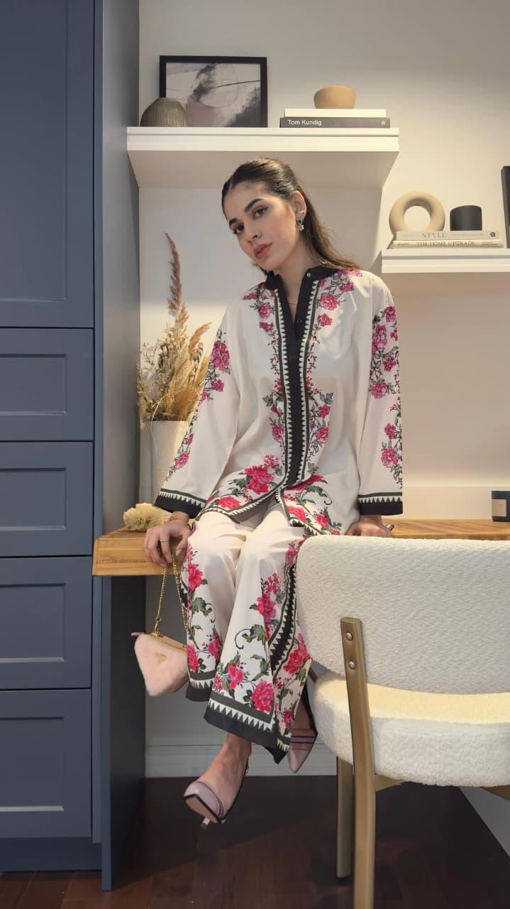 Woman in a floral outfit sitting on a chair in a room with shelves and decor Glanzavi