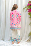 Person wearing a pink floral kimono-style garment with white pants against a white curtain background Glanzavi